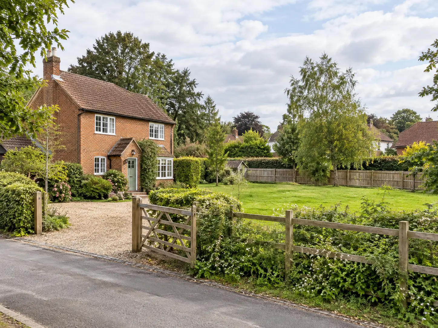 Illustrative brick house with adjoining garden and gated access from a village lane.